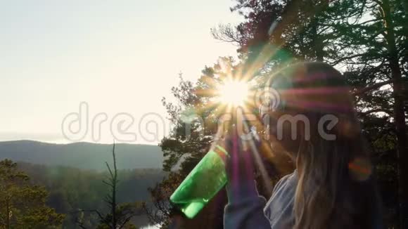 山里的女孩从瓶子里喝水视频的预览图