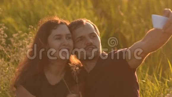 日落时分浪漫的情侣在公园里散步并自拍视频的预览图