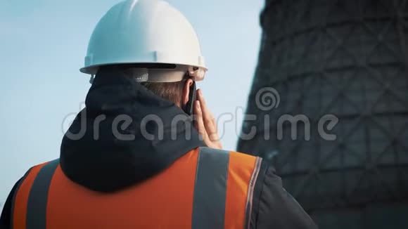 专业工程师戴着白色头盔和夹克看着工厂的管道她打电话来从冷却视频的预览图