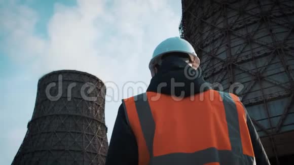 专业工程师戴着白色头盔和夹克看着工厂的管道她打电话来从冷却视频的预览图