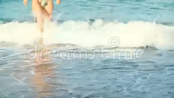 在海滩上女人美丽的晒黑的腿海上行走的女孩视频的预览图