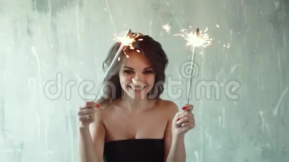 可爱的年轻女孩拿着火花玩得很开心年轻迷人的女人高兴地挥舞着火花慢动作视频的预览图
