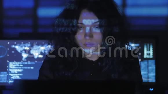 一位卷发的黑客女程序员在电脑安全中心工作里面放满了显示屏视频的预览图