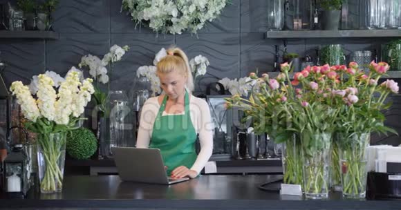 在花店里有笔记本电脑的女人视频的预览图