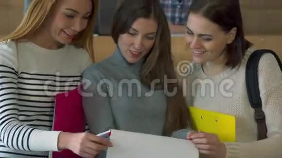 三名女学生观看插图杂志视频的预览图