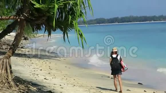 带着背包和帽子走在美丽的海岸线上的女孩视频的预览图