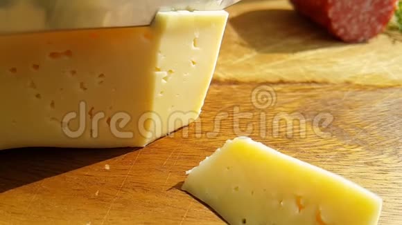 用刀子切出的奶酪在木制桌子上烹饪传统的慢镜头视频的预览图