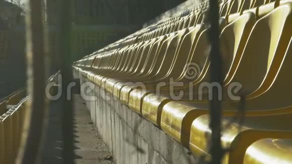 黄色椅子在一个金属栅栏后面的空体育场慢动作120fps视频的预览图
