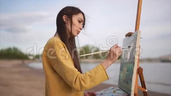 一个年轻的女人在露天画架上画一支画笔画架上画着一个静物视频的预览图