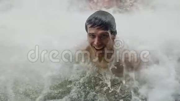 快乐的帅哥在热带丛林的瀑布下在溪水下放松游泳慢动作1920x1080高清视频的预览图