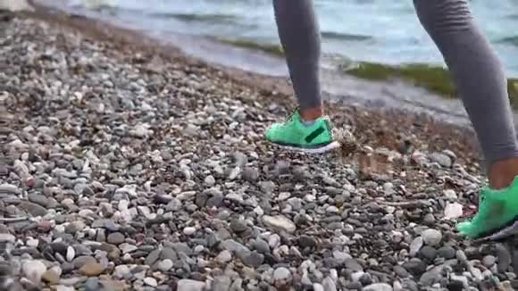 一个年轻女子的近距离她沿着石岸奔跑视频的预览图