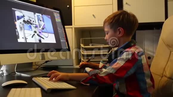 聪明的男孩为他的电脑做一个项目男孩在电脑上工作用的是图形平板电脑视频的预览图