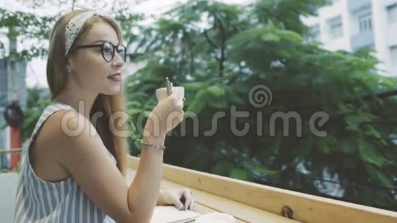 写日记的女人情绪化的女性在笔记本上写作在咖啡馆喝咖啡视频的预览图