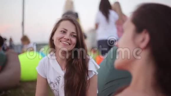 两个年轻快乐的黑发女孩在公园里聊天夏日里美丽的朋友笑嘻嘻的视频的预览图