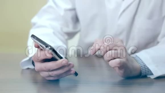 医生用手机和平板电脑使用电子设备的男性医生视频的预览图