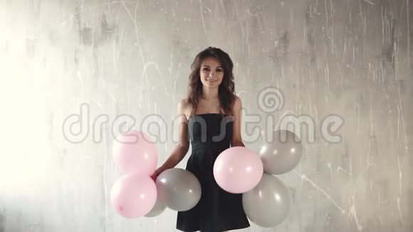 快乐的年轻女子抛出气球和微笑节日的气氛庆祝的感觉慢动作视频的预览图