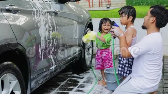 年轻人和他的孩子们在洗车视频的预览图