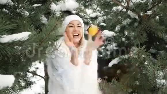 美丽的金发女郎在冬季风景的背景下吃橘子视频的预览图