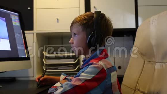 聪明的男孩为他的电脑做一个项目男孩在电脑上工作用的是图形平板电脑视频的预览图