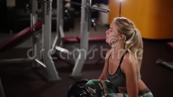 一个女人在健身俱乐部里用杠铃做运动视频的预览图