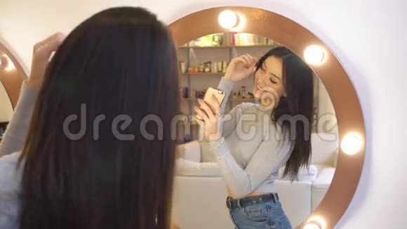 年轻漂亮的女孩在镜子前照了一张自己的照片4她在美容院里得到了极好的反映视频的预览图