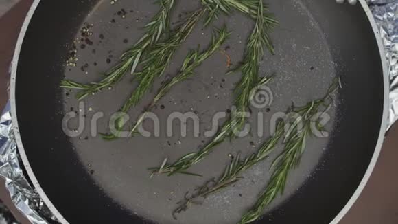 厨师把五条鱼放在煎锅里放在黑胡椒和迷迭香枝上视频的预览图