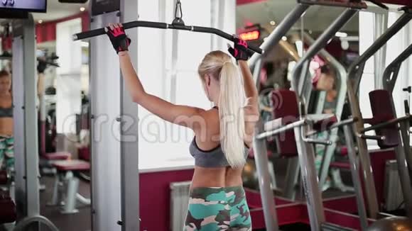 健身房里的女人在健身教练的帮助下做运动视频的预览图