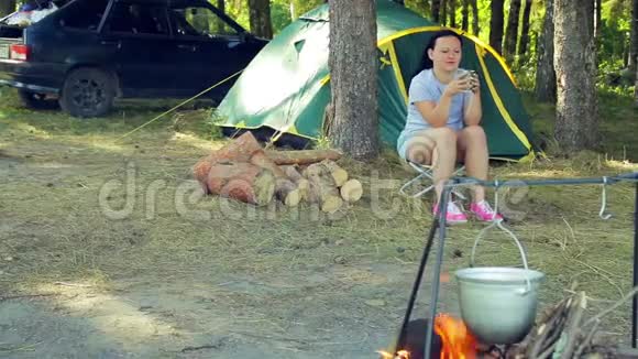 帐篷附近的一个年轻女子正在喝茶视频的预览图