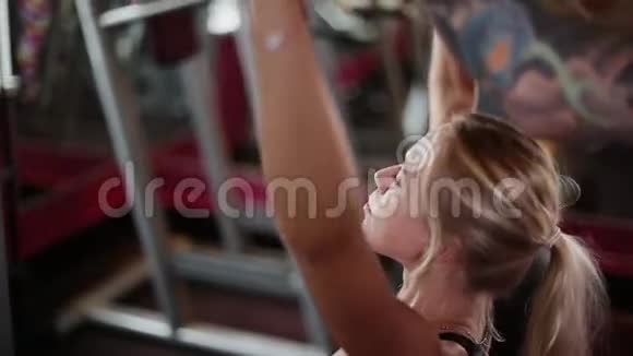 健身房里的女人在健身教练的帮助下做运动视频的预览图