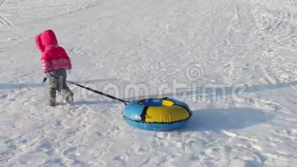 小女孩从山上滑下雪管两个无法辨认的大人和小孩在山上视频的预览图