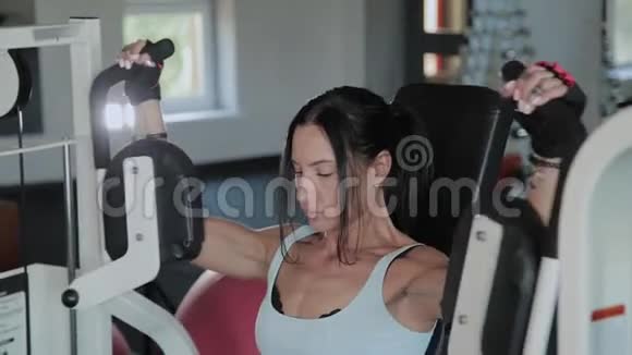 美丽的运动女性在模拟器上训练胸肌视频的预览图