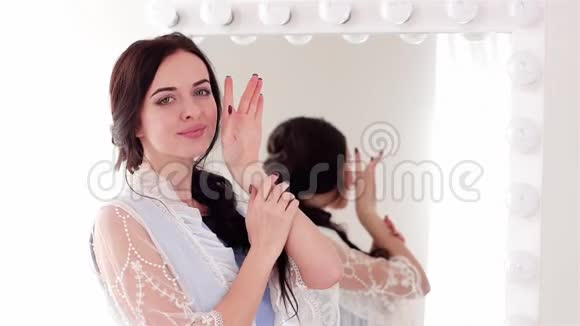柔滑的脸颊女人在镜子前摆着相机粉唇指甲的女孩视频的预览图