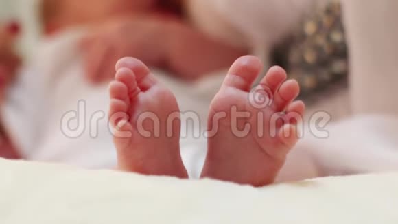 女人的手在房间的床上抚摸婴儿的小脚视频的预览图