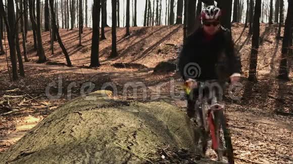 一个骑自行车的人停下来检查他的智能手表站在覆盖的叶子里视频的预览图