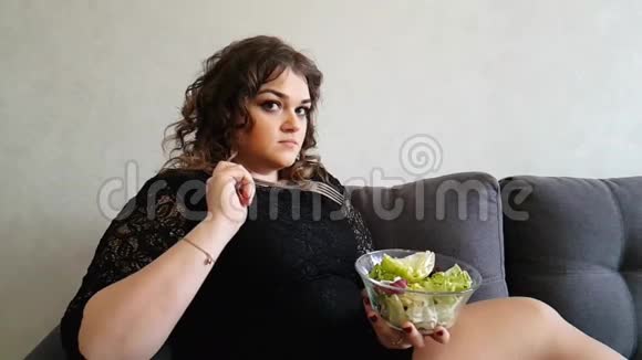 美丽的女孩吃沙拉沙发饥饿的情感开胃菜视频的预览图