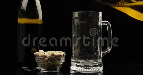 把冷的淡啤酒从瓶子里倒入玻璃杯里手工艺啤酒特写视频的预览图