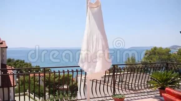 新娘礼服迎风飘扬在阳台上视频的预览图
