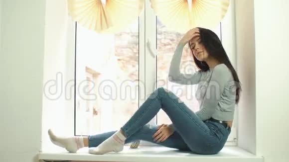 美丽的女孩摆在窗台上视频的预览图