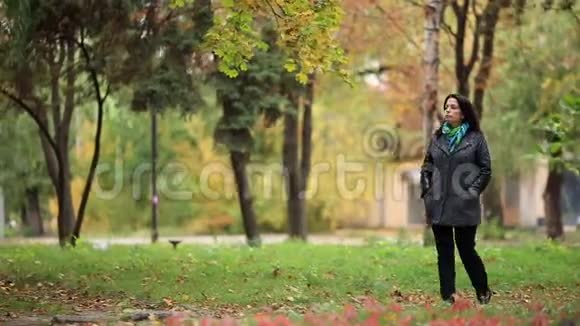 年轻女子独自漫步在秋天的公园里视频的预览图