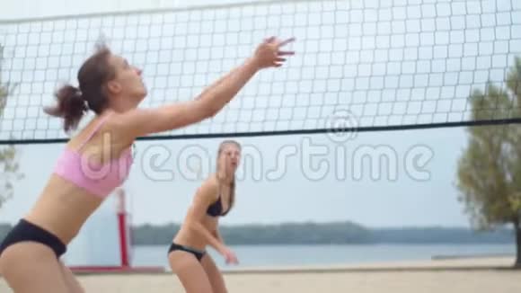 海滩上的女人正在打排球击球4K视频的预览图