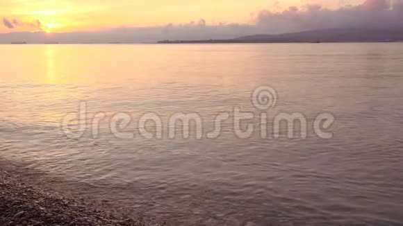 美丽的日落越过海滩船在远处视频的预览图