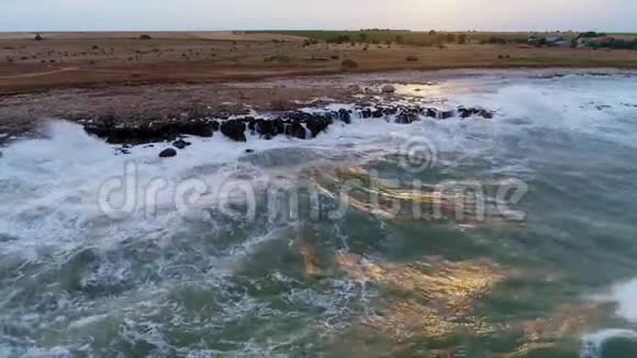 岩石海岸线的鸟瞰海浪拍打羊群成群视频的预览图