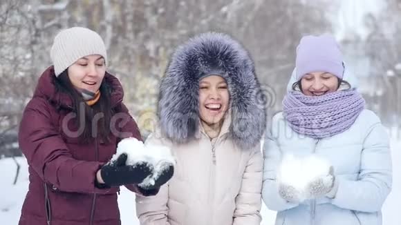 快乐的美丽女孩在公园散步时玩着扔雪球视频的预览图