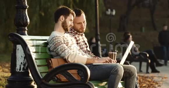 两个拿着诺博克的家伙在外面的椅子上在阳光下说话红色史诗4k视频的预览图
