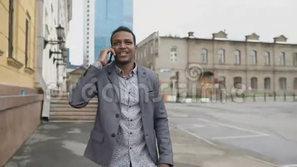 Stadicam拍摄的混合种族快乐商人跳舞和谈论他的新职业的电话视频的预览图