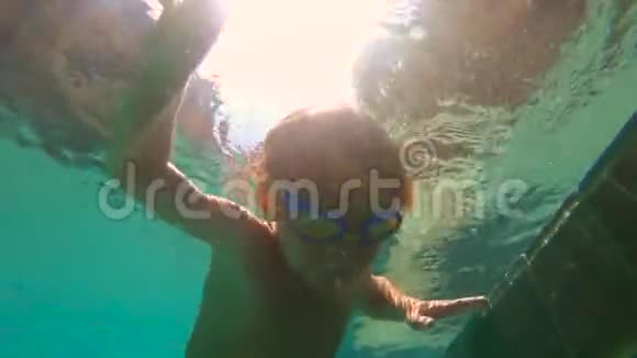 一个小男孩在水下拍摄的超HD慢动作学习如何在游泳池里游泳幼儿男孩潜入游泳池拉视频的预览图