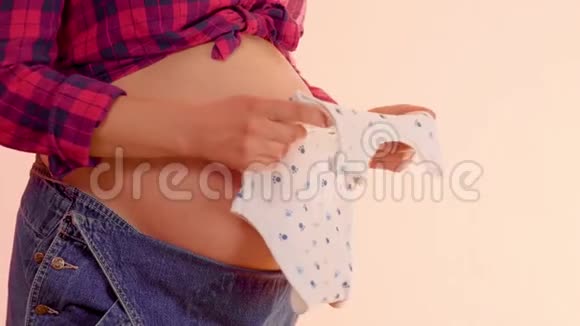 孕妇手里拿着新生的阴蒂放在她赤裸的大肚子上怀着可爱宝宝的孕妇视频的预览图