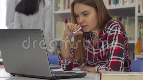 女学生在图书馆把笔放在嘴里视频的预览图