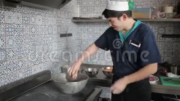 厨房工人把肉放进锅里视频的预览图