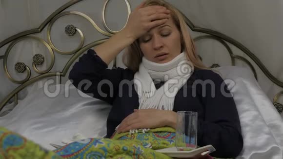 生病的女人咳嗽喝了一片药女孩躺在床上脖子上戴着一条温暖的围巾4K视频的预览图